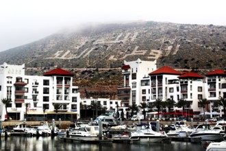The marina of Agadir with modern buildings in front of a hill with lettering, Agadir, Morocco