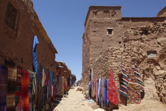 Narrow alley with colorful textile presentation in Ait Benhaddou, Ait Benhaddou, Ouarzazate,