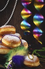 Berliner with powdered sugar, decorated with pearl necklaces and colorful spirals against a dark