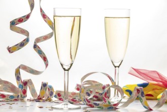 Two champagne glasses filled with colorful streamers, carnival