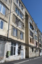 Multi-storey apartment unit with visible cables and worn exterior façade, Gori, Inner Kartli