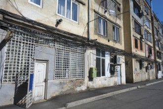 Multi-storey apartment block with lots of exposed cables and aged façade, Gori, Inner Kartli