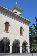 Historic building with decorated façade and a flag against a blue sky, Josef Stalin Museum, Gori,
