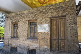 Brick wall of a building with wooden doors and windows, rustic appearance, birthplace of Josef