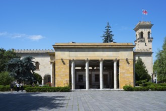 Historic building with columns and Georgian flag in clear blue sky, Josef Stalin Museum, Gori,