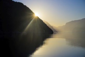 Sun shines over a mountain in the Lysefjordfjord bathed in calm, soft light, view from the Columbus