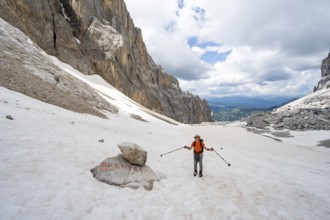 Mountaineers on a snowfield, guide to Rifugio Brentei on a rock, remains of the Vedretta dei