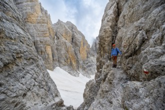 Mountaineer climbs on a steep rock face in the Via Ferrata dell'Ideale via ferrata, spectacular