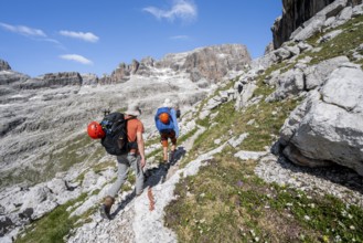 Two mountaineers on a hiking trail to Sella della Tosa, mountainous landscape in the Brenta
