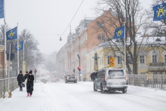 Pedestrians and cars on the snow-covered Auransilta bridge that crosses the Aurajoki River, wintery