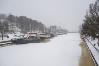 Ships moored on the banks of the frozen Aurajoki River, wintery Turku or Swedish Åbo,