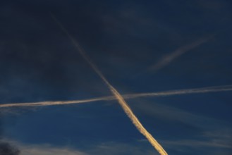 Contrails cross in the evening sky, Upper Austria, Austria