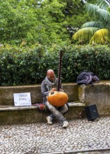 Musician sitting on the side of the N375 road in Sintra, Lisbon, Portugal