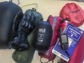 Bakum, Melle, Lower Saxony, Germany, camping equipment on a table with tent, stove, gloves and GPS