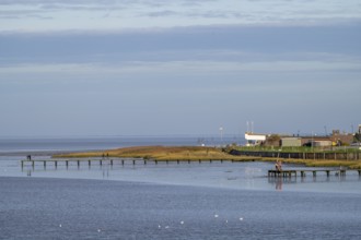 A coastline with footbridges and buildings under a wide, blue sky, Wadden Sea National Park, Jade