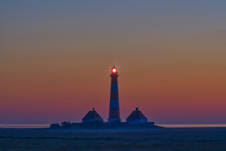 Silhouette of a lighthouse at sunset by the sea, calm and peaceful atmosphere