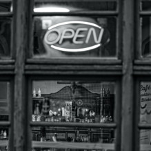 A cozy, open, vintage-style café behind a black and white window