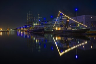 Nightport with illuminated ships and light reflections in the water