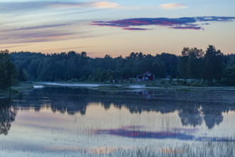 Tranquil river landscape at sunset with forest and gentle water