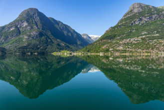 Tranquil mountain and lake landscape with clear, reflecting water surface