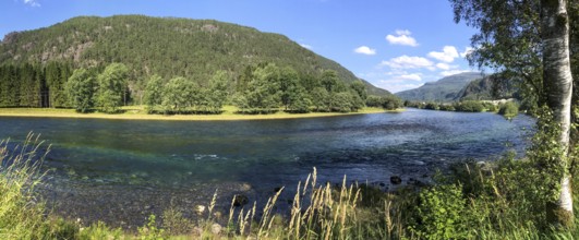 Sand, Rogaland Municipality, Norway, Clear river surrounded by green trees and meadows under a blue