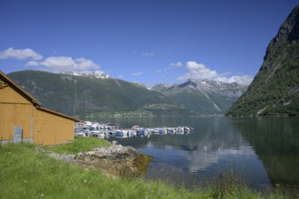 Norddal, Møre og Romsdal province, Norway, wooden cabin on the shore of a fjord with boats and