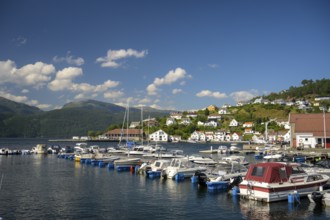 Sand, Rogaland municipality, Norway, boats in the harbor in front of a city with mountains and blue