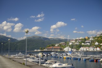 Sand, Rogaland municipality, Norway, harbour full of boats in front of a city with mountains in the