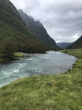 Byrkjelo, Vestland, Norway, river flows through a valley surrounded by green meadows and thick