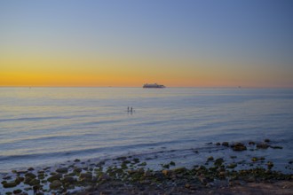 Hirtshals, Nordjylland region, Denmark, sunset over a calm sea with gentle waves and rocks on the
