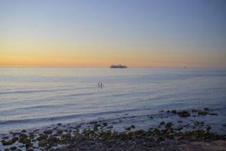 Hirtshals, Nordjylland region, Denmark, sunset over a calm sea with gentle waves and rocks on the
