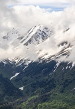 Fog sweeps around mountain peaks with remnants of snow, view from Slaughter Ridge Trail, Cooper