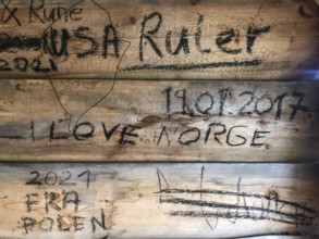 Drevsjø, Innlandet, Norway, wooden wall with graffiti and inscriptions, including countries and