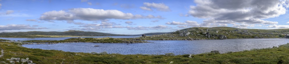 Haugastøl, Viken, Norway, vast landscape with a lake under a cloudy blue sky in Hardangervidda
