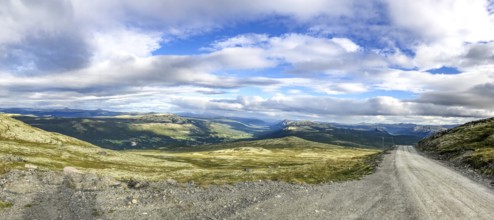 Tylldal, Innlandet, Norway, panoramic view of mountains and a dirt road under cloudy sky, Norway's