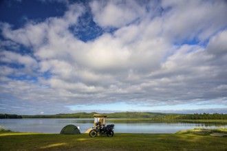 Rörström, Dorotea, Västerbotten, Sweden, motorcycle and tent on the shore of a large lake under a