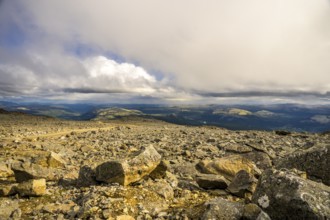 Alvdal, Innlandet, Norway, far-reaching view over a rocky landscape under a dramatic sky, road to