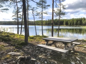Storsjö Kapell, Jämtlands län, Sweden, A Scandinavian picnic table with fixed benches on the shore