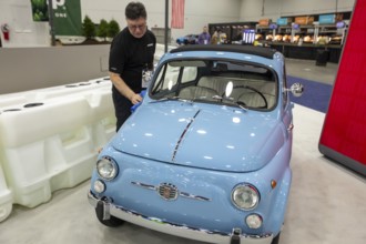 Detroit, Michigan USA - 15 January 2026 - A worker polishes a 1962 Fiat 500 at the Detroit Auto