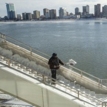 Detroit, Michigan USA - 15 January 2026 - A worker shovels snow from steps leading to Huntington