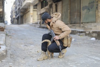 In Aleppo, Syria on January 10, 2026, a Syrian Army soldier crouches to pet a stray cat in the