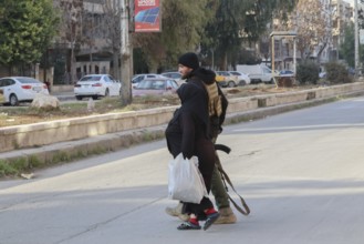 In Aleppo, Syria on January 10, 2026, Syrian Army soldiers assist and secure an elderly woman
