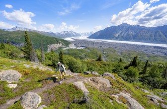 Young man on a hiking trail, view of impressive mountain landscape with Matanuska glacier and