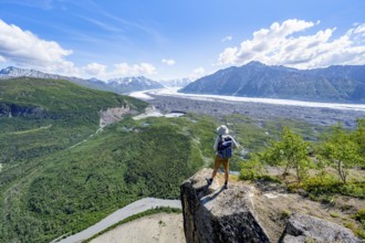 Young man on a rocky outcrop enjoying the view, view of impressive mountain scenery with Matanuska