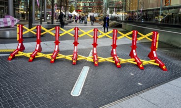 Massive metal access barriers in red and yellow at Center Potsdamer Platz, Berlin, Germany