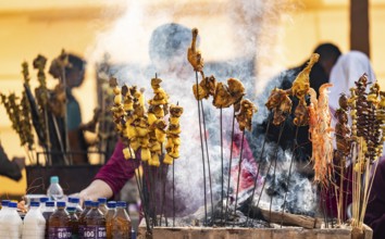 Vendor selling roasted meat at a stall in Bhogali Mela, ahead of the 'Magh Bihu' festival, in
