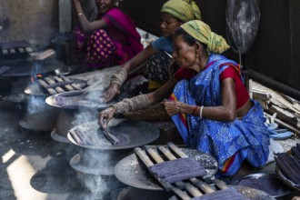 Women prepare 'Pitha', Assamese traditional rice-based sweets or snacks, as part of preparations