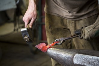 A blacksmith forging, working at the Ehnert forge in Dresden-Bühlau, Saxony, Germany