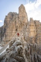 Mountaineer climbs an exposed rock in the secured Via Ferrata Bocciere Centrale via ferrata,