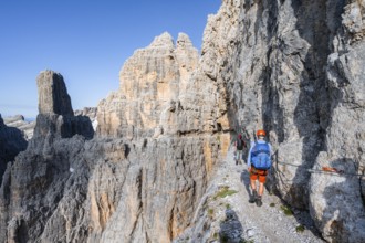 Two mountaineers on an exposed rock band in the secured Via Ferrata Bocciere Centrale via ferrata,